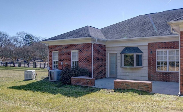 view of side of home featuring a patio area, central AC unit, and a lawn