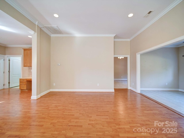 unfurnished room featuring visible vents, baseboards, light wood-style floors, and ornamental molding