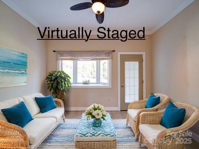 tiled living area featuring a ceiling fan, baseboards, and ornamental molding