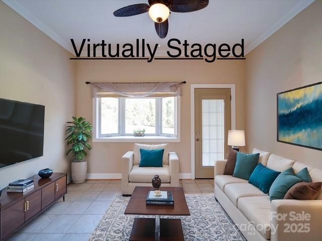 living room featuring light tile patterned flooring, a ceiling fan, crown molding, and baseboards