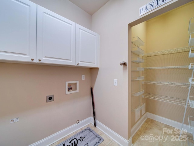 laundry room with light tile patterned floors, baseboards, hookup for an electric dryer, cabinet space, and washer hookup