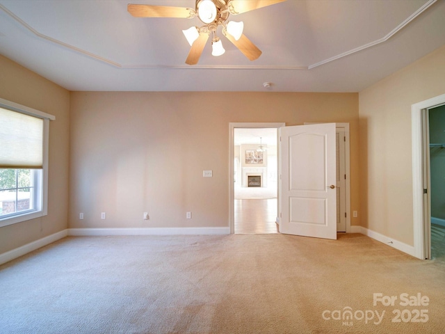 empty room featuring baseboards, light colored carpet, and ceiling fan