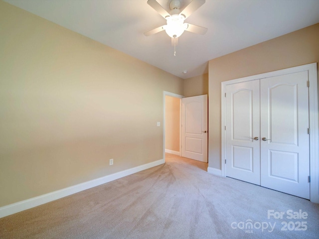 unfurnished bedroom with carpet flooring, a ceiling fan, baseboards, and a closet