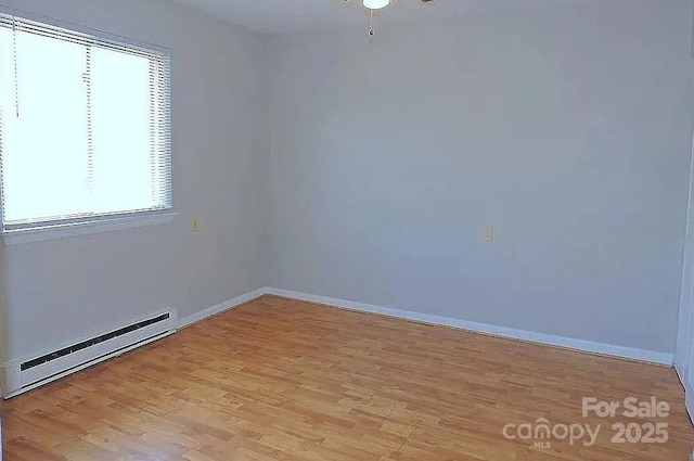 spare room featuring light hardwood / wood-style flooring and a baseboard radiator