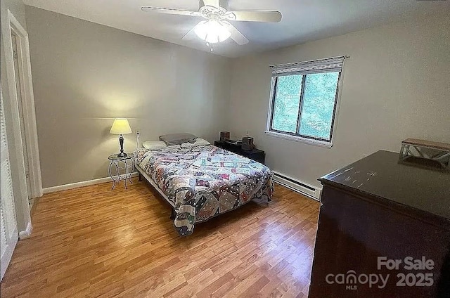 bedroom featuring hardwood / wood-style flooring, a baseboard radiator, and ceiling fan