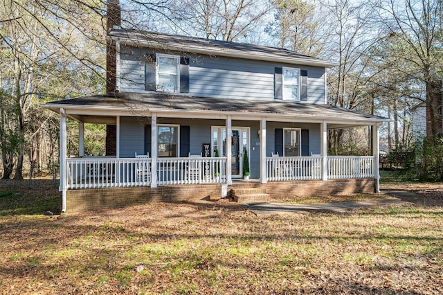 farmhouse inspired home with a front lawn and a porch