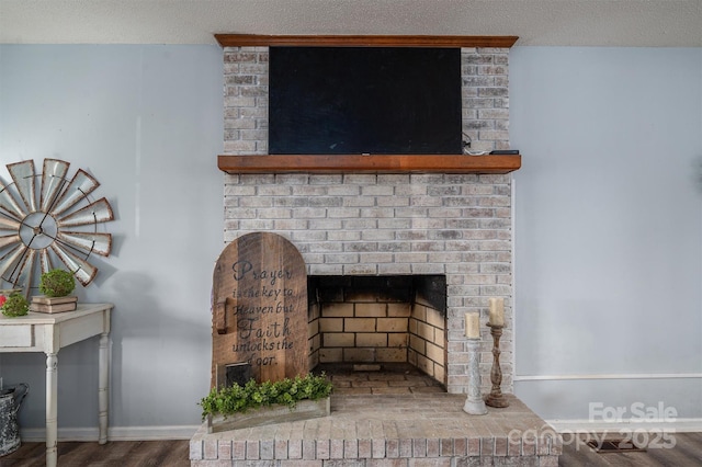 interior details with wood-type flooring, a fireplace, and a textured ceiling