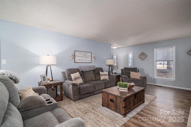 living room featuring a textured ceiling and light wood-type flooring