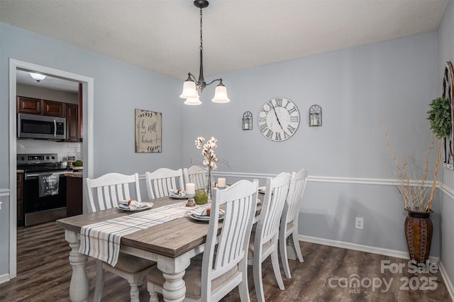 dining space featuring dark hardwood / wood-style flooring, a textured ceiling, and a chandelier