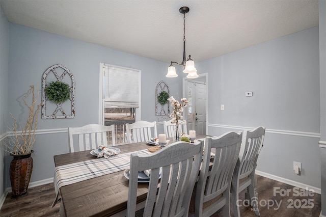 dining area featuring dark wood-type flooring and a textured ceiling