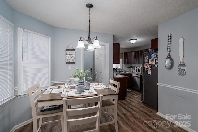 dining room featuring dark hardwood / wood-style floors, an inviting chandelier, and a textured ceiling