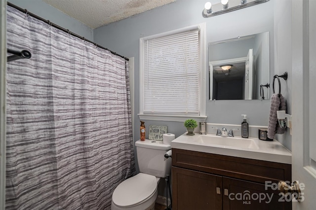 bathroom featuring vanity, a shower with shower curtain, a textured ceiling, and toilet