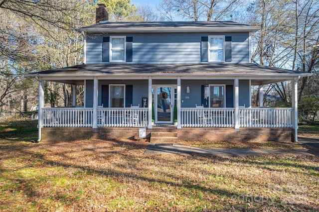 farmhouse featuring a front lawn and a porch