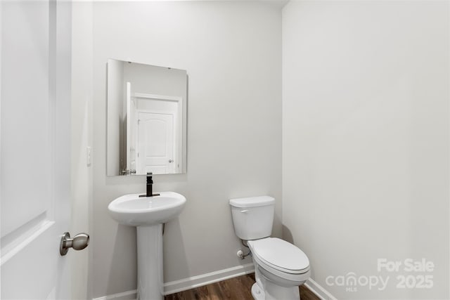 bathroom with wood-type flooring and toilet