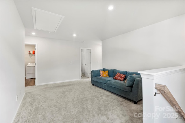 carpeted living room featuring washer / dryer