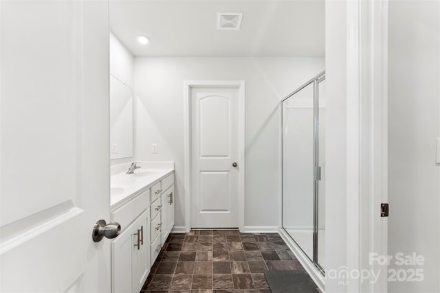 bathroom featuring vanity and a shower with shower door