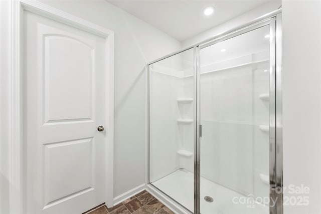 bathroom featuring a shower with door