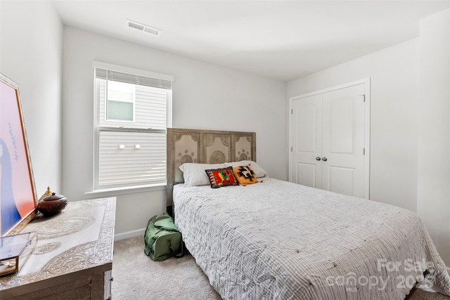 bedroom featuring light colored carpet and a closet