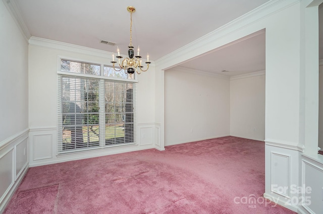 empty room featuring crown molding, a chandelier, and carpet