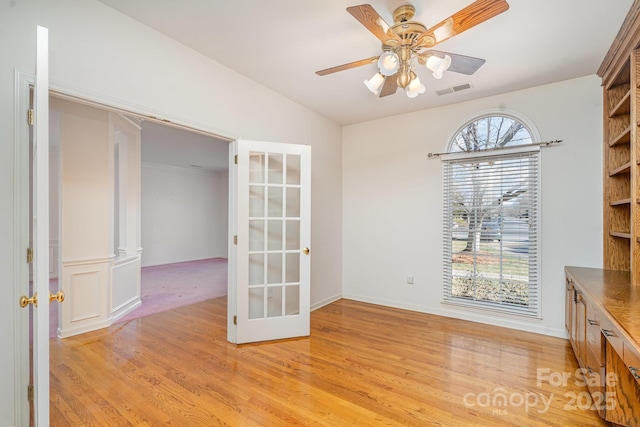 unfurnished dining area with ceiling fan, lofted ceiling, and light wood-type flooring