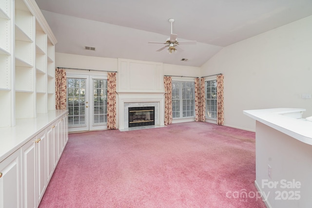 unfurnished living room featuring ceiling fan, lofted ceiling, light carpet, and a fireplace