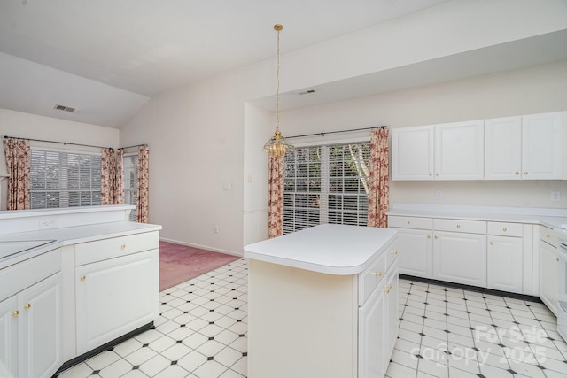 kitchen featuring pendant lighting, white cabinetry, lofted ceiling, and a kitchen island