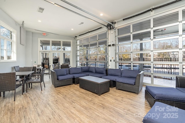 living room with a high ceiling and light hardwood / wood-style flooring