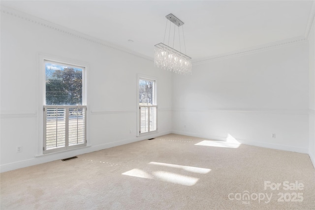 empty room featuring an inviting chandelier, ornamental molding, and carpet