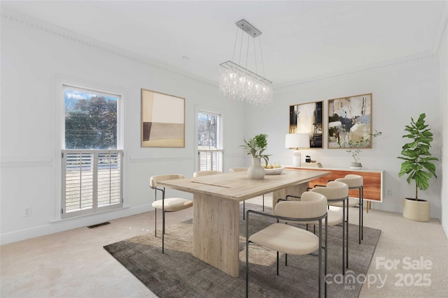 dining space featuring a notable chandelier, ornamental molding, and light colored carpet