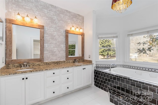 bathroom with vanity, brick wall, a relaxing tiled tub, and tile patterned floors