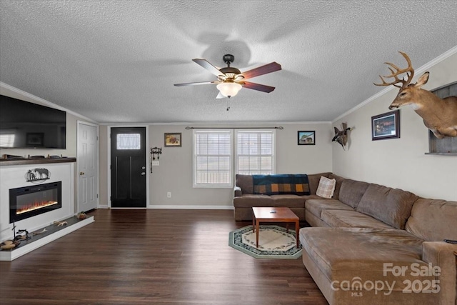 living room featuring dark wood-type flooring, ceiling fan, ornamental molding, and a textured ceiling