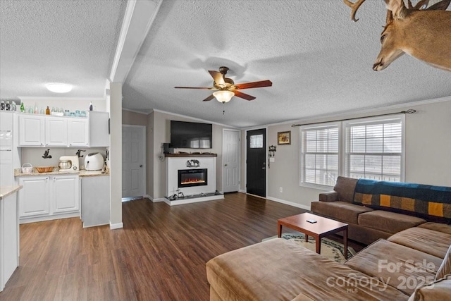 living room featuring crown molding, dark wood-type flooring, ceiling fan, a textured ceiling, and vaulted ceiling