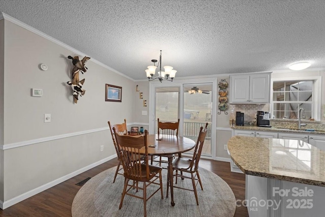 dining area featuring dark hardwood / wood-style floors, lofted ceiling, sink, a chandelier, and ornamental molding