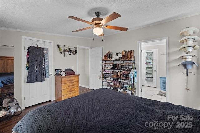 bedroom with ornamental molding, hardwood / wood-style floors, ceiling fan, and a textured ceiling