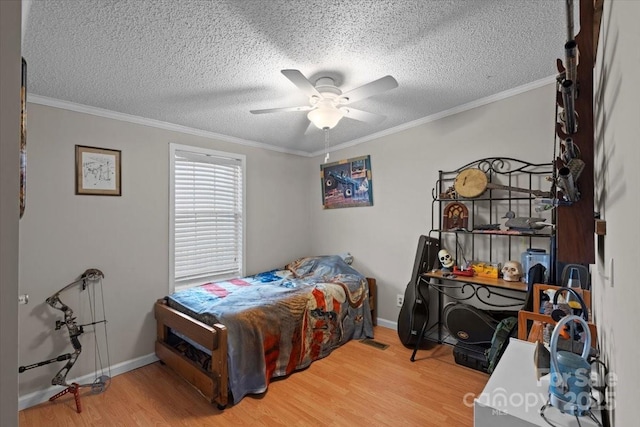 bedroom with ceiling fan, crown molding, wood-type flooring, and a textured ceiling