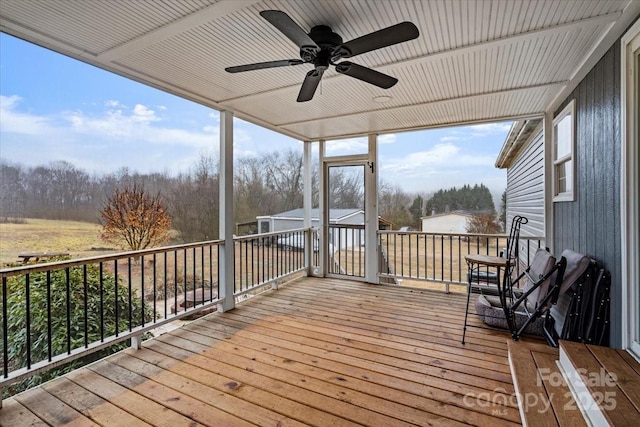 unfurnished sunroom featuring ceiling fan