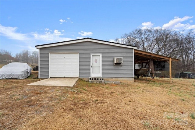 garage featuring a lawn and a wall mounted AC