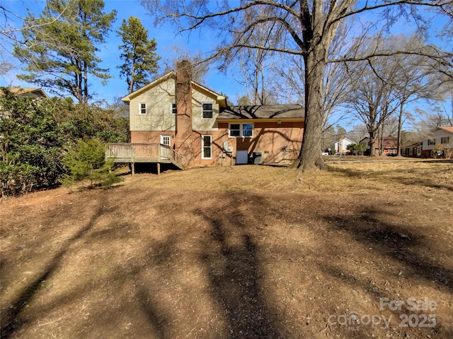 rear view of property featuring a wooden deck