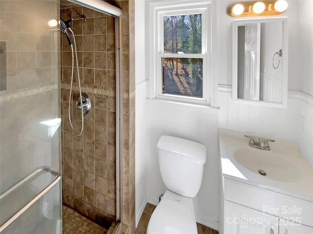 bathroom featuring vanity, toilet, and a shower with shower door