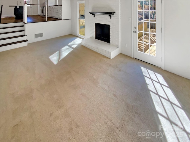 unfurnished living room featuring a wealth of natural light and light colored carpet