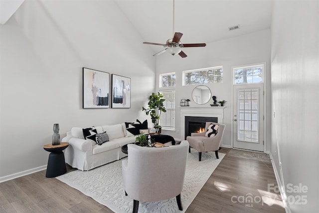 living room with hardwood / wood-style flooring, a healthy amount of sunlight, and high vaulted ceiling