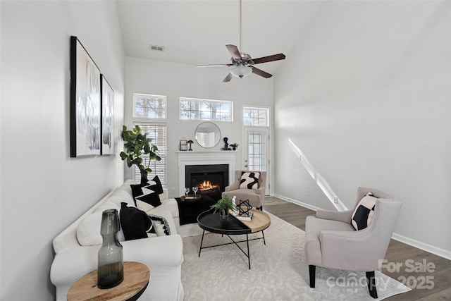 living room featuring hardwood / wood-style floors, high vaulted ceiling, and ceiling fan