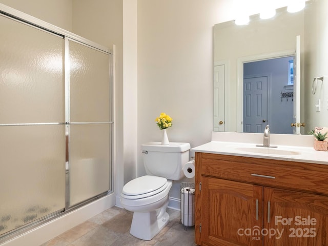 bathroom with vanity, a shower with shower door, and toilet