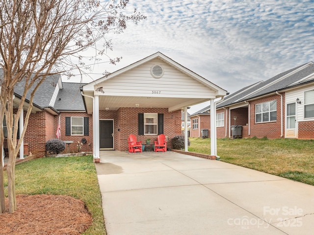 view of front of home featuring a carport, a front yard, and central AC unit