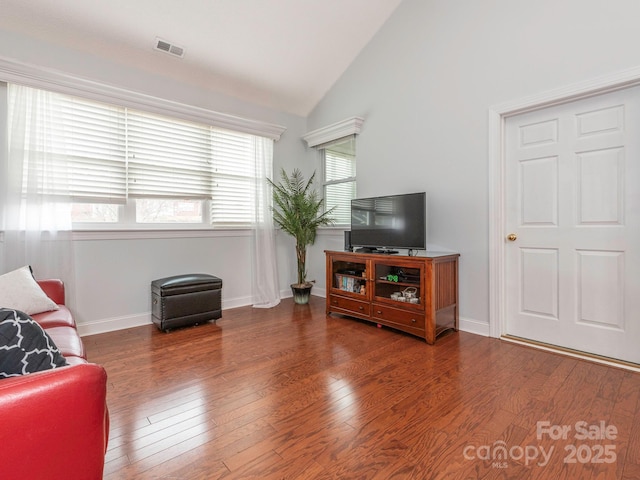 living room featuring lofted ceiling and hardwood / wood-style floors