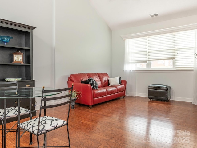 living room featuring dark hardwood / wood-style flooring and vaulted ceiling