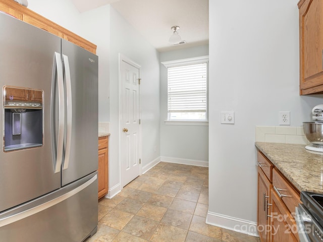 kitchen with light stone counters and appliances with stainless steel finishes