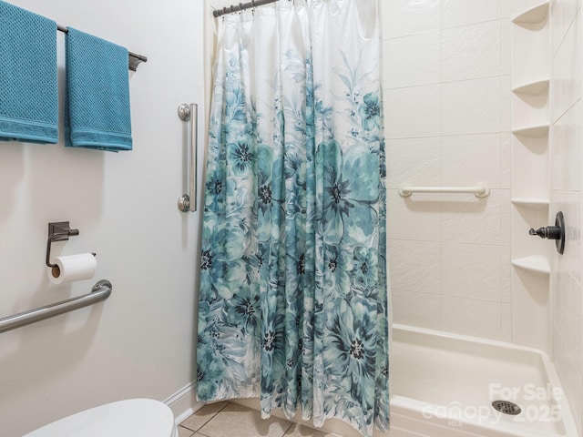 bathroom featuring toilet, tile patterned flooring, and a shower with shower curtain