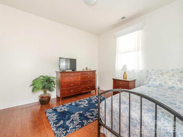 bedroom with dark hardwood / wood-style floors