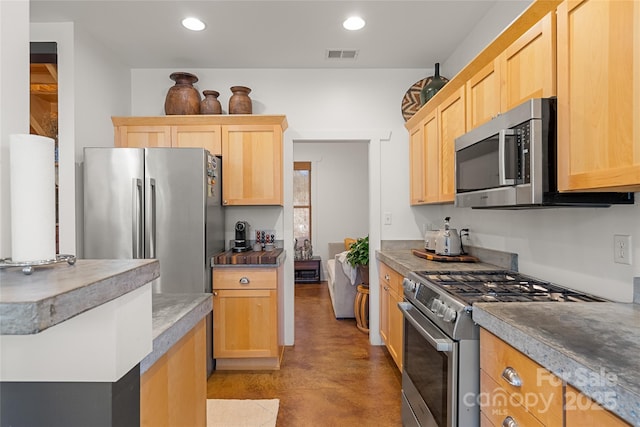 kitchen featuring stainless steel appliances and light brown cabinetry